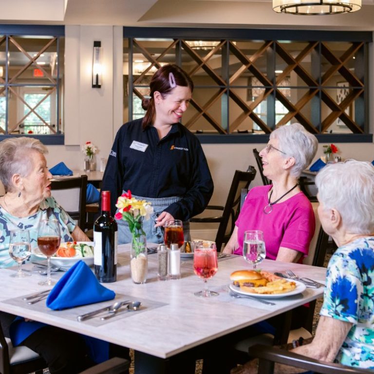 Someren Glen Senior Living Community in Centennial, CO - three residents and dining team member talking square